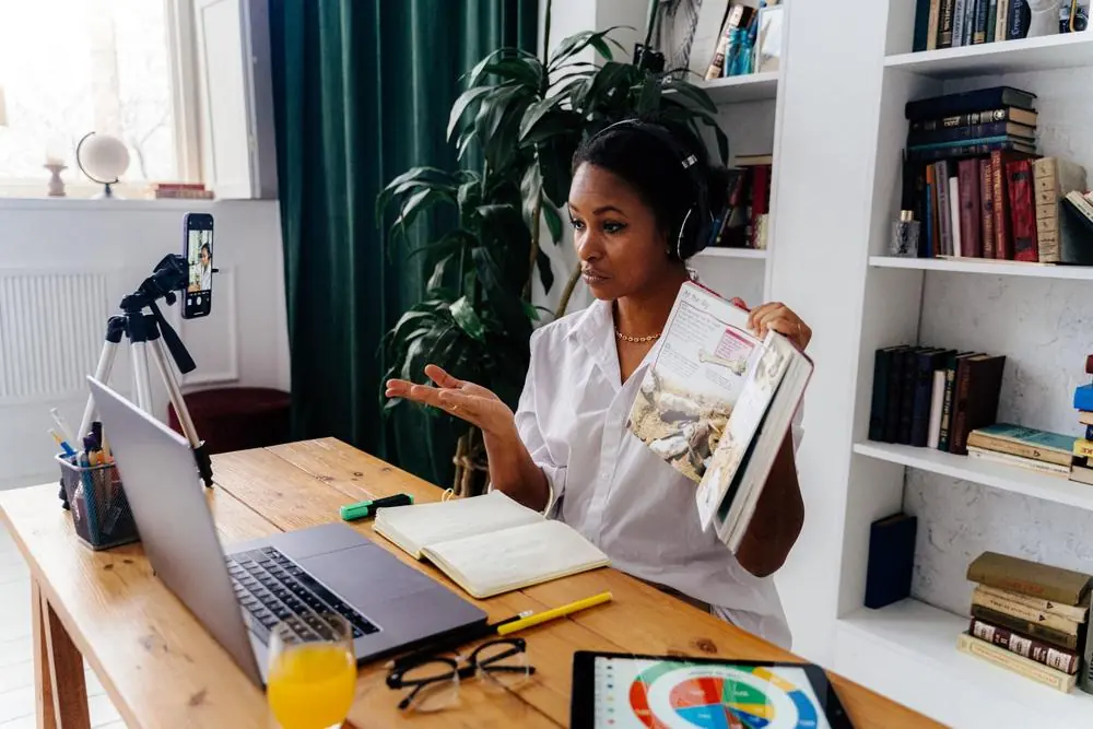 Teacher holding a book during an online lesson